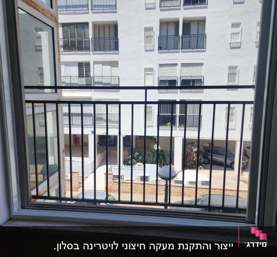 חלון עם מסגרת מתכת ומעקה חיצוני